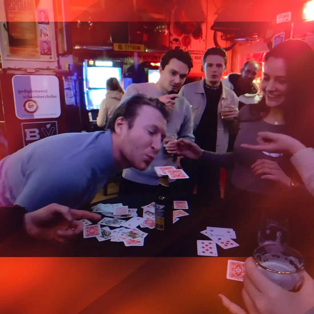 Vrienden aan een kaartspel met een borrel in De Typhoon