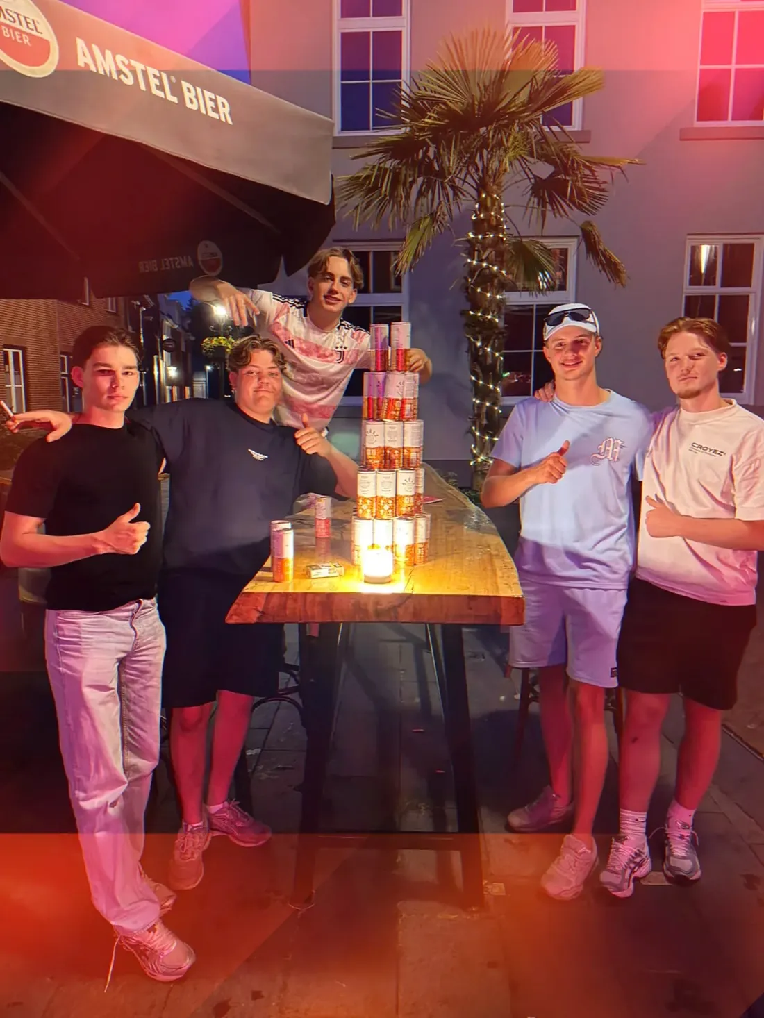 Jongens met een blikjestoren op het terras van De Typhoon